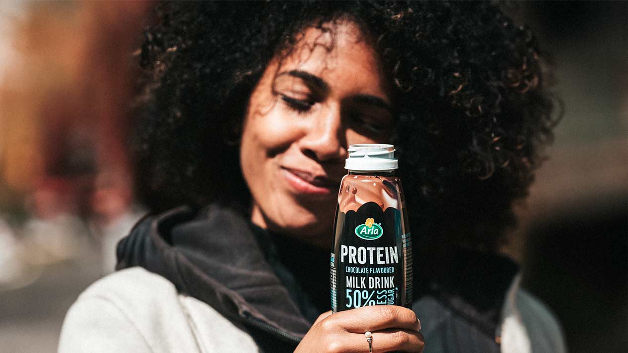 Mujer bebiendo batido proteínas de Arla Protein en campeonato de padel
